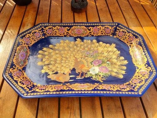 a blue and gold plate with flowers on a wooden table at Péniche Chaleureuse avec jacuzzi Toulouse centre in Toulouse