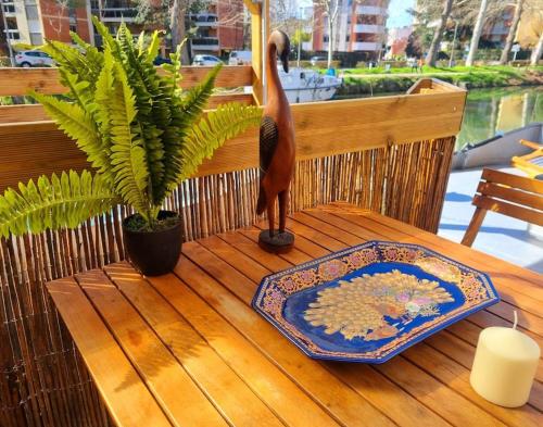 a bird statue sitting on a table with a plate at Péniche Chaleureuse avec jacuzzi Toulouse centre in Toulouse