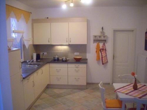 BojendorfにあるLandhaus Kopendorfのキッチン(白いキャビネット、テーブル、シンク付)