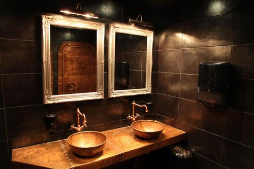 een badkamer met 2 houten wastafels en een spiegel bij Volkhov Most in Chudovo