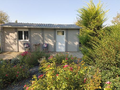 mała szopa z dwoma krzesłami w ogrodzie w obiekcie Gîte Nature et détente w mieście Aubréville