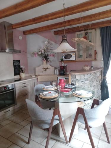 une salle à manger avec une table et des chaises dans une cuisine dans l'établissement Maison de village l autentic, à Aussois