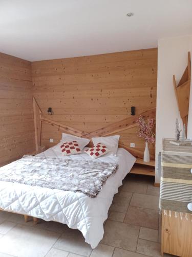 une chambre avec un lit et un mur en bois dans l'établissement Maison de village l autentic, à Aussois