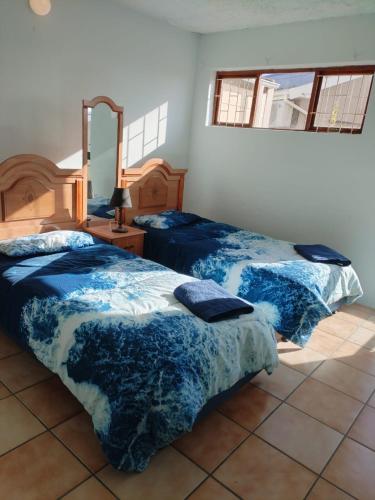 a bedroom with two beds and a mirror at Rus 'n Bietjie in Witsand