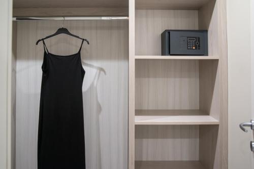 a black dress hanging in a closet with a tv at Hotel Degli Ulivi in Ferrandina