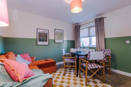 a living room with a couch and a table and a dining room at Practical 2 Bedroom House Perfect for Contractors in Grimsby by PureStay - 7 night min! in Grimsby