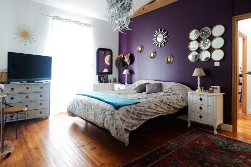 - une chambre avec un lit et un mur violet dans l'établissement Jolie maison sablaise avec jardin quartier Arago et proche plage, Les Sables - 8 personnes, à Les Sables-dʼOlonne