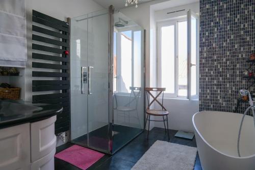 une salle de bain avec une douche en verre et une baignoire dans l'établissement Jolie maison sablaise avec jardin quartier Arago et proche plage, Les Sables - 8 personnes, à Les Sables-dʼOlonne