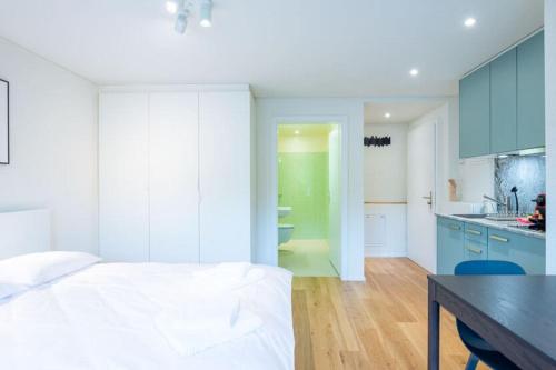 a bedroom with a bed and a kitchen with blue cabinets at HITrental Riesbach Apartments in Zürich