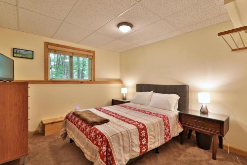 ein Schlafzimmer mit Bett, Schreibtisch und Fenster in der Unterkunft Killington Mountain Retreat -Great Group Ski House! Close to Resort - Hot Tub - Ski Rental Deals in Killington