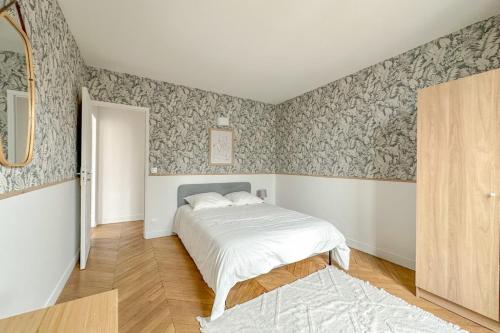 - une chambre avec un lit et du papier peint floral dans l'établissement Flexliving - room - Septembre, à Paris