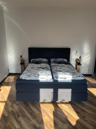 a large bed in a room with wooden floors at Hinter der Alten Post in Annaberg-Buchholz