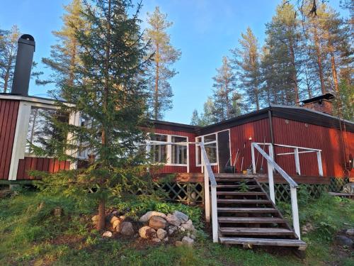 Un furgón de cola rojo con una escalera que conduce hasta él. en Kaamos Old House, en Rovaniemi