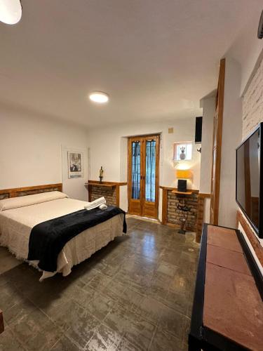 Un dormitorio con una cama y un televisor de pantalla plana. en Apartamento Carretera de la Sierra, en Granada