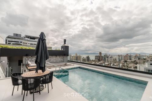 a balcony with a pool and a table and chairs at LGDs - Apartamentos no Centro de Florianópolis in Florianópolis