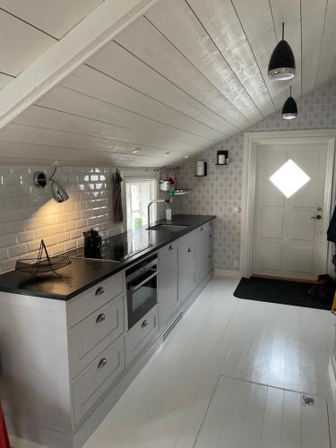 a kitchen with white cabinets and black counter tops at Båtmansstugan i Gamla Stan in Kalmar