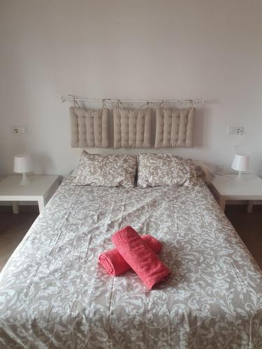 a bed with two red towels on top of it at PISO CENTRICO CON GARAJE en Hellin in Hellín