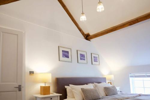 a bedroom with a bed and two pictures on the wall at Flora Dora - Luxury cottage - modern - central - ideal for groups and families in Filey