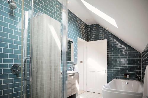a bathroom with blue tiles and a sink and a toilet at Flora Dora - Luxury cottage - modern - central - ideal for groups and families in Filey