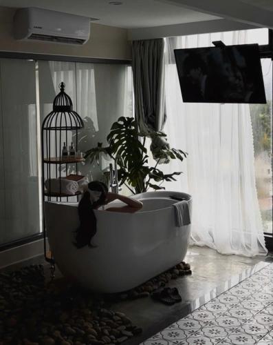 a woman sitting in a bath tub in a room at The Manor Villas Da Lat in Xuan An