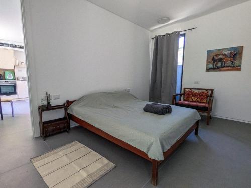 a bedroom with a bed and a chair in it at Between Valley & Mountain in Yoqne‘am