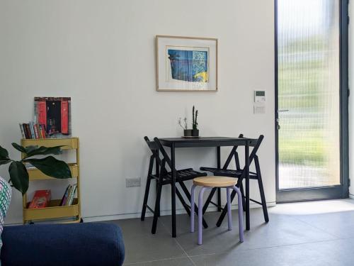 a table and two stools in a room at Between Valley & Mountain in Yoqne‘am