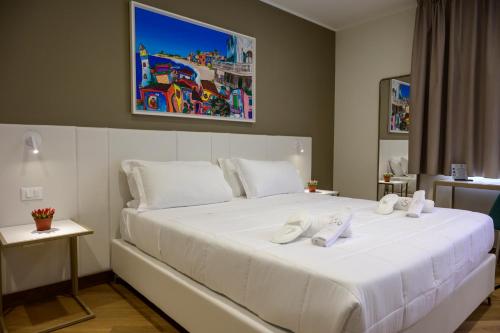 Un dormitorio con una gran cama blanca con zapatos encima. en B&B Maqueda - Room & Suite, en Palermo