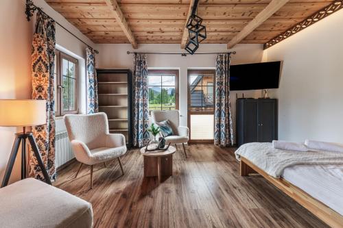 a bedroom with a bed and two chairs at Apartamenty Truchanówka przy Dolinie Chochołowskiej in Witów
