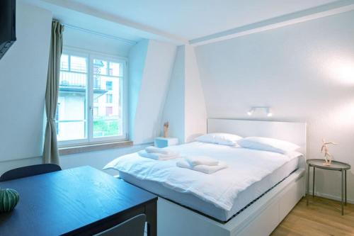 a blue bedroom with a large bed and a desk at HITrental Riesbach Apartments in Zürich