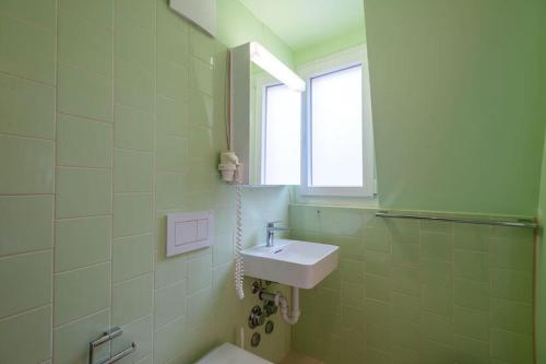 a bathroom with a sink and a window at HITrental Riesbach Apartments in Zürich