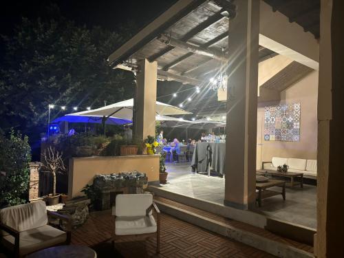 a patio with a table and chairs at night at VillaGrancassa Hotel Relais in San Donato Val di Comino