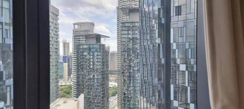 a view from a window of a city with tall buildings at Star KLCC Elegant 2-3pax by DingDing in Kuala Lumpur