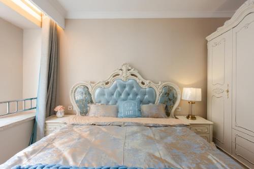 a bed with a blue headboard in a bedroom at Damei Xian -Kunming Road Branch in Xi'an