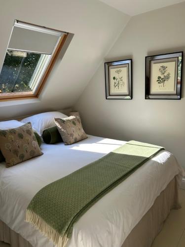 a bedroom with a bed with a green blanket on it at Idyllic rural retreat in Plumpton Green