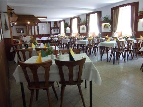 une salle à manger avec des tables et des chaises dans un restaurant dans l'établissement Europäisches Gäste- und Seminarhaus, à Todtmoos