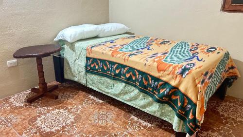 a bed with a pillow and a table in a room at Casa Cesar in Santa Cruz La Laguna