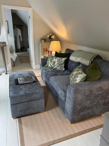 a living room with a couch and a ottoman at Idyllic rural retreat in Plumpton Green