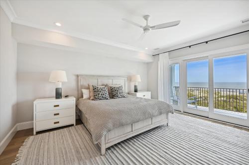 a white bedroom with a bed and a balcony at 3 Singleton Beach - Oceanfront Estate, Private Pool, Elevator, FREE Activities Included in Hilton Head Island