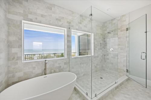 a bathroom with a shower and a tub and a window at 3 Singleton Beach - Oceanfront Estate, Private Pool, Elevator, FREE Activities Included in Hilton Head Island