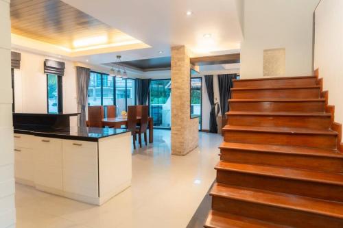 a staircase in a house with a kitchen and a dining room at Thai Home 23 3BR near Hollywood in Pattaya Central