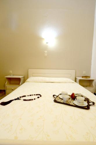a bed with two plates and two cups on it at Golden Apartments in Agios Nikolaos