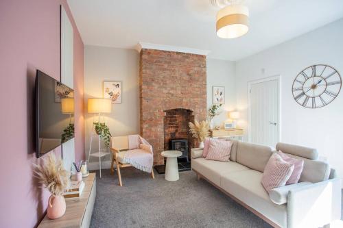 a living room with a couch and a fireplace at Balmoral Gardens - Vacant Nests in North Shields