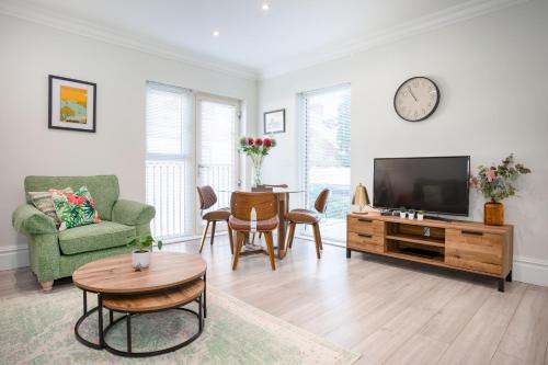 a living room with a television and a table at 5 Star - The Ulsterville Residences - Free On-site Parking in Belfast