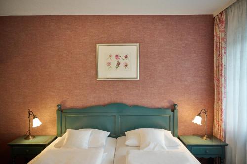 a bedroom with two beds and a picture on the wall at Kucher's Landhotel in Darscheid