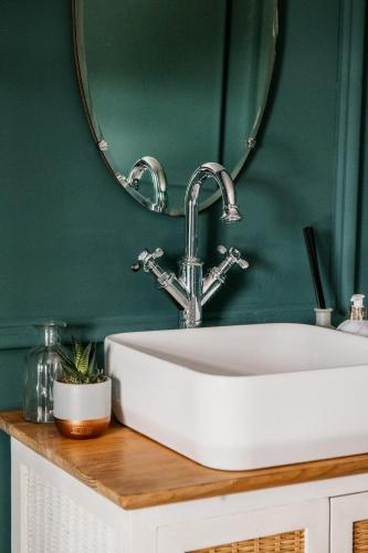 a bathroom with a white sink and a mirror at The Heathcock Boutique Hotel - Room 2 in Cardiff