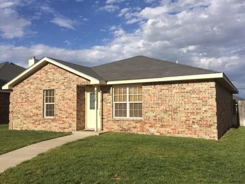 a brick house with a grass yard at McKinley House - Gym, Garage and Fenced Yard in Amarillo