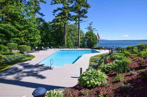 a swimming pool on a deck next to the water at Lakefront At Winnipesaukee in Gilford