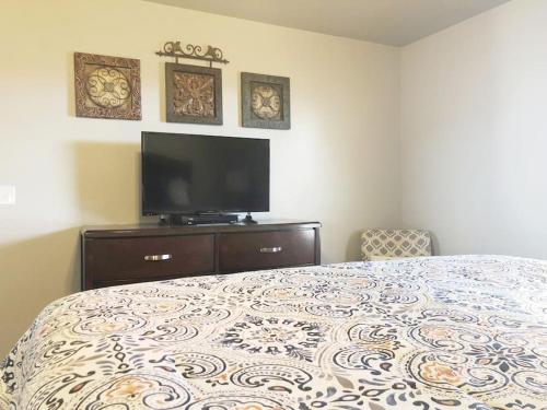a bedroom with a bed and a flat screen tv at McKinley House - Gym, Garage and Fenced Yard in Amarillo