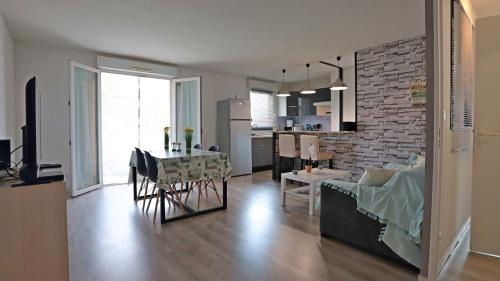Il dispose d'une cuisine et d'un salon avec une table et un canapé. dans l'établissement Appart T2 dans résidence calme Parking privé gratuit, à Miramas