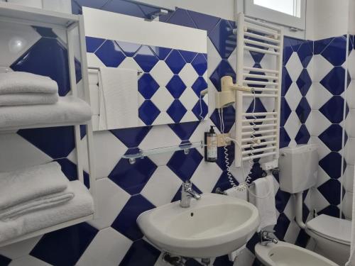 a blue and white bathroom with a sink and a toilet at Appart-Hotel Holiday in Lignano Sabbiadoro
